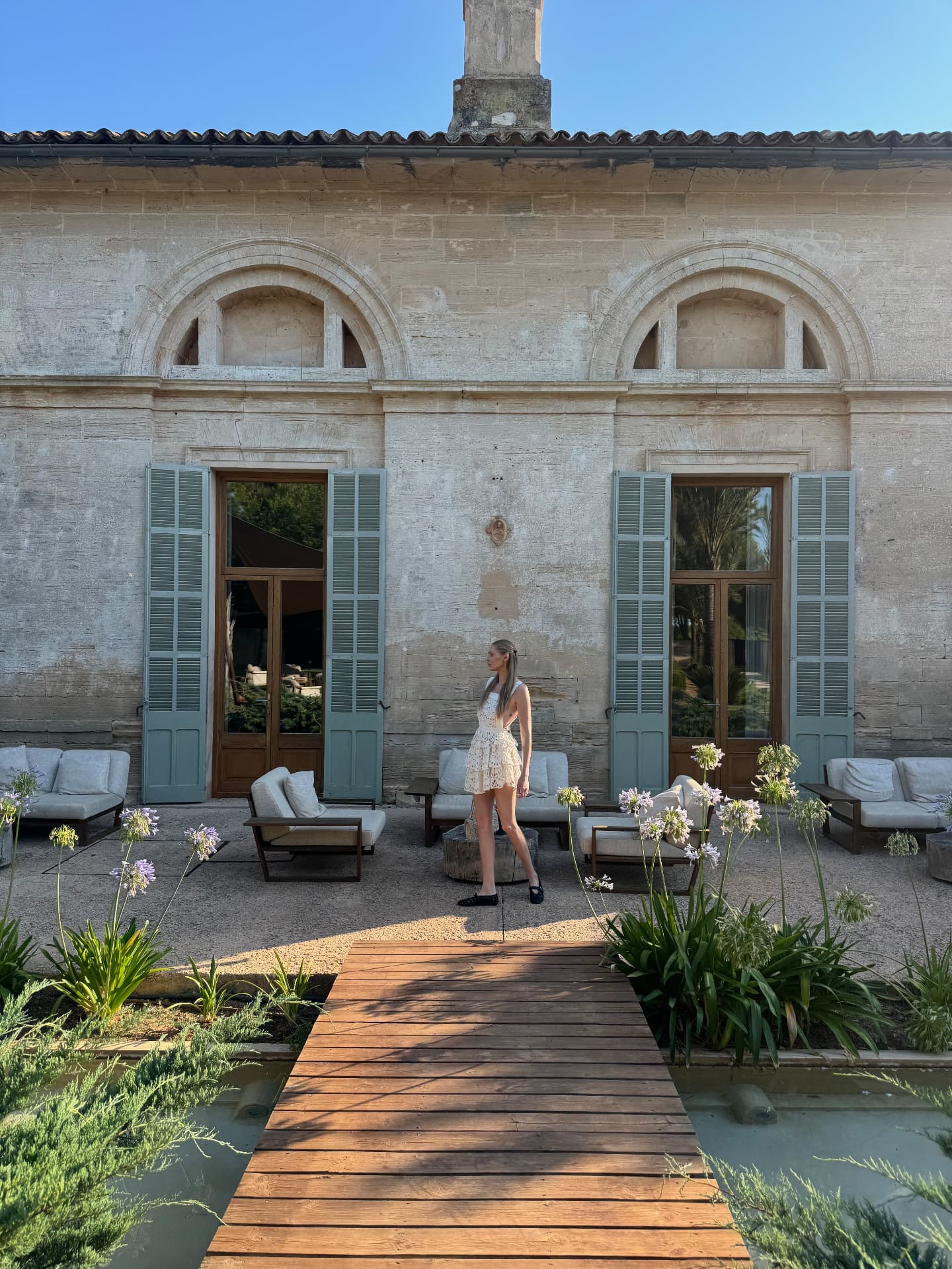 Natalie in a sunlit stone courtyard