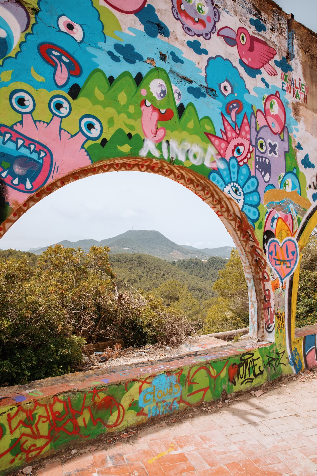 Colorful street art framing a mountain landscape